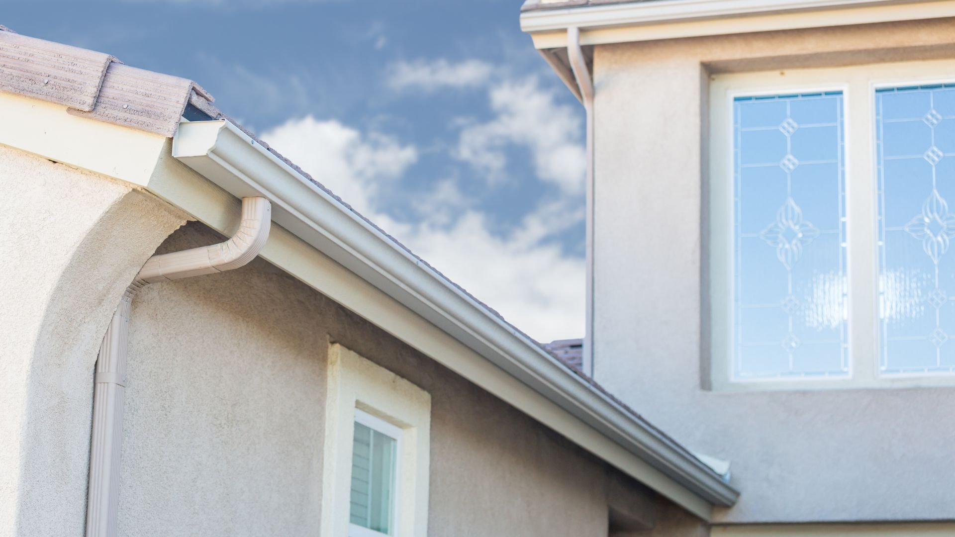 White gutter and roof edge of modern house against blue sky